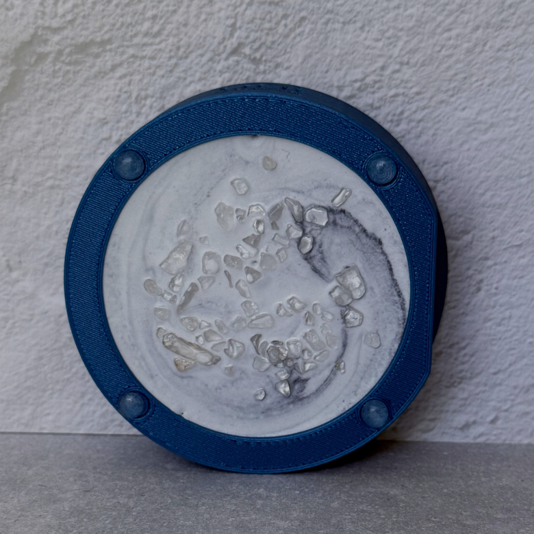 The base is handcrafted from a proprietary blend of approximately 60% clear crystals and 40% mineral resin. Each piece is individually cast and sealed with a protective clear finish, resulting in subtle variations that make every piece unique.